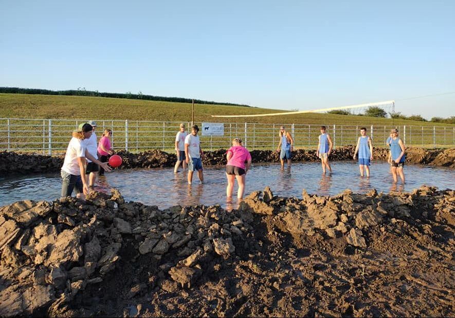 Two team compete play volleyball in the mud